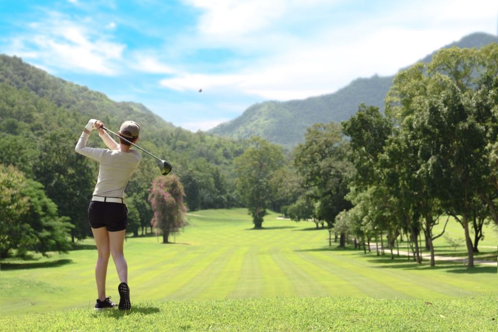 Young Asian woman playing golf on a beautiful natural golf course