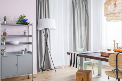 Room with grey window curtain, metal bookcase and wood table