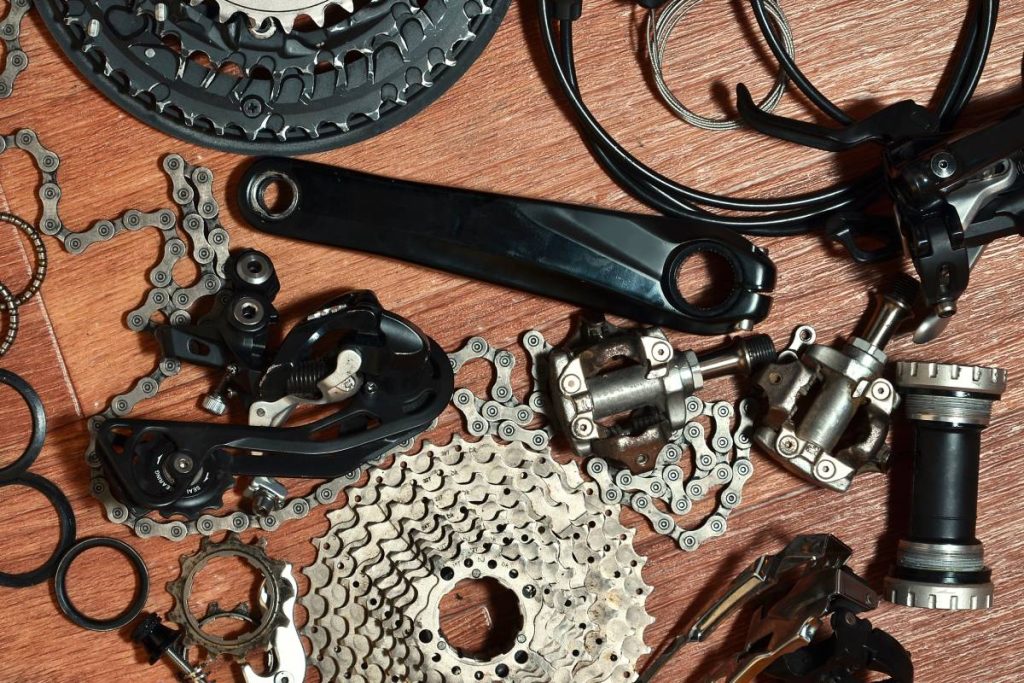 Many different metal parts and components of the running gear of a sports bike. Brake levers, sprockets, gears, pinions and many other components for bicycle assembly. Bicycle repair concept