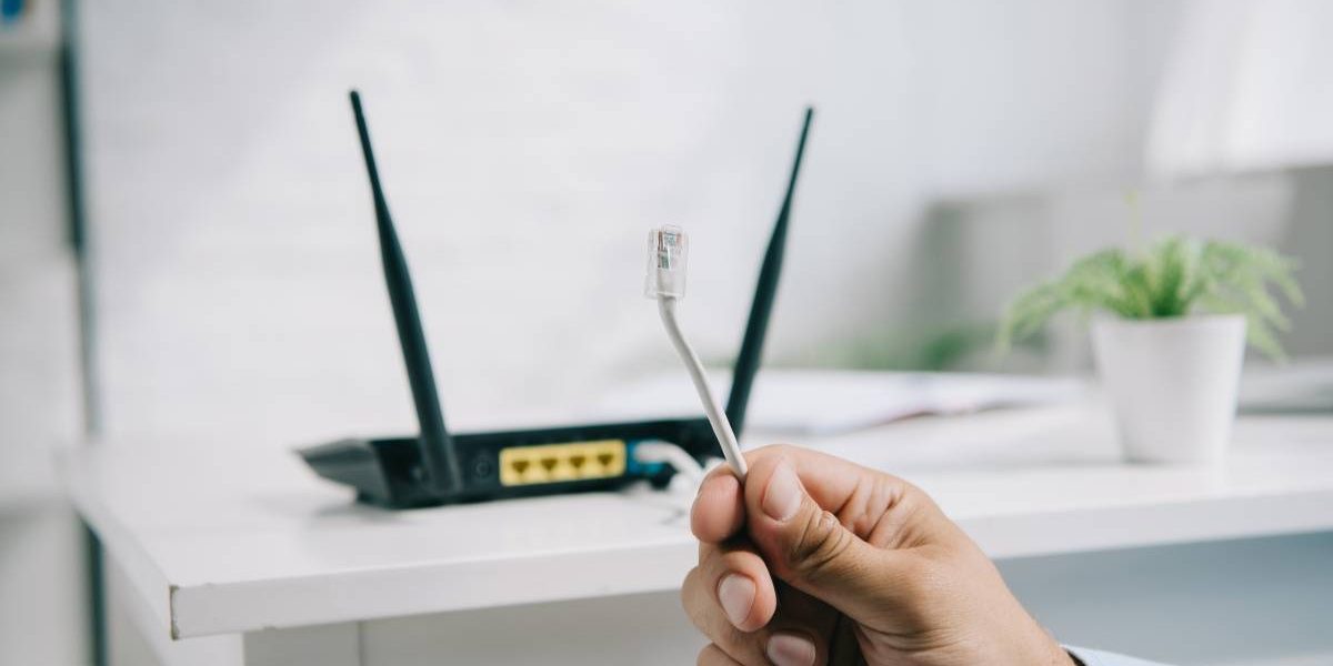 cropped view of businessman holding wire with connector near router