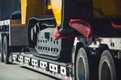 Long Haul Heavy Duty Construction Transport an Excavator on a Semi Truck Trailer. Excavator Delivery.