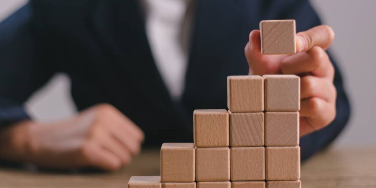 Businesswomen stack blank wooden cubes on the table with copy space, empty wooden cubes for input wording, and an infographic icon.