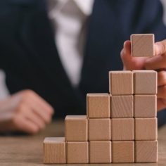 Businesswomen stack blank wooden cubes on the table with copy space, empty wooden cubes for input wording, and an infographic icon.
