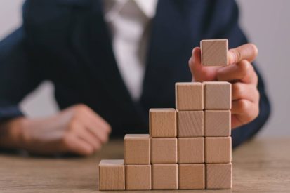 Businesswomen stack blank wooden cubes on the table with copy space, empty wooden cubes for input wording, and an infographic icon.