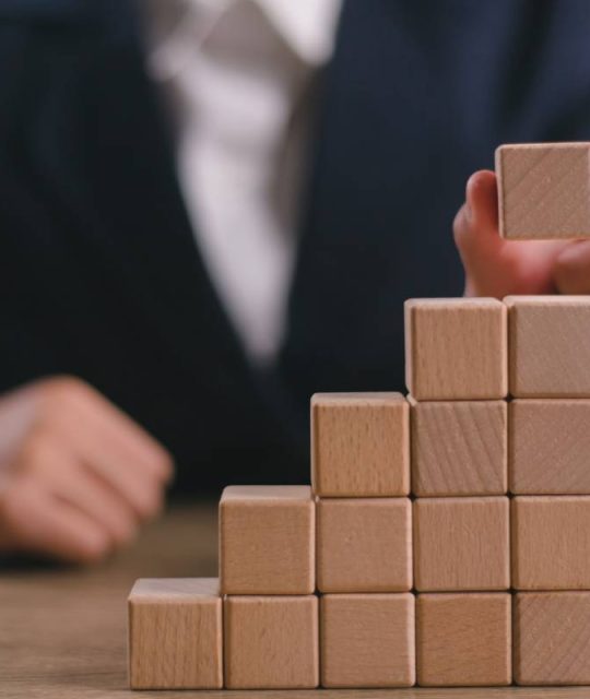 Businesswomen stack blank wooden cubes on the table with copy space, empty wooden cubes for input wording, and an infographic icon.
