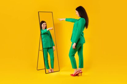 I choose myself. Excited stylish lady pointing finger at her reflection in mirror, yellow background, free space