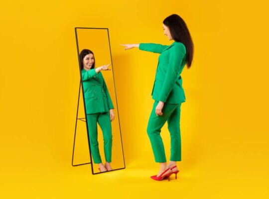 I choose myself. Excited stylish lady pointing finger at her reflection in mirror, yellow background, free space