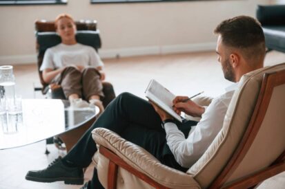 Woman is sitting in chair at an appointment with a Therapy psychologist