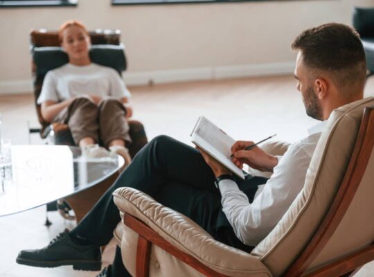 Woman is sitting in chair at an appointment with a Therapy psychologist