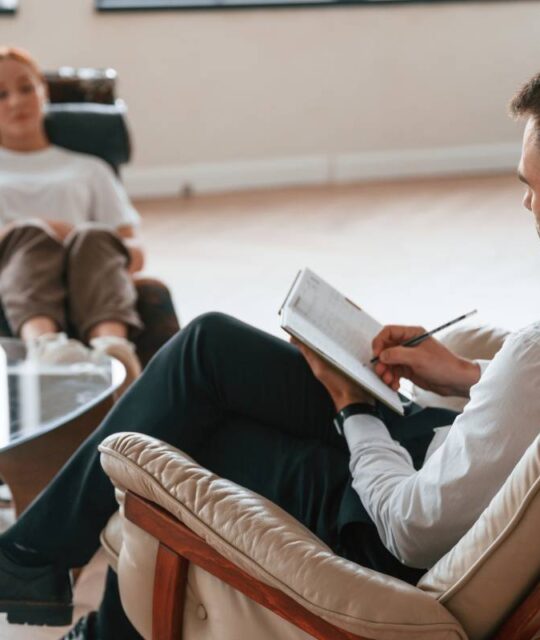 Woman is sitting in chair at an appointment with a Therapy psychologist