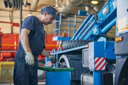 Profile photo of serious man that bowing his head while looking at case with instrument, being in workshop